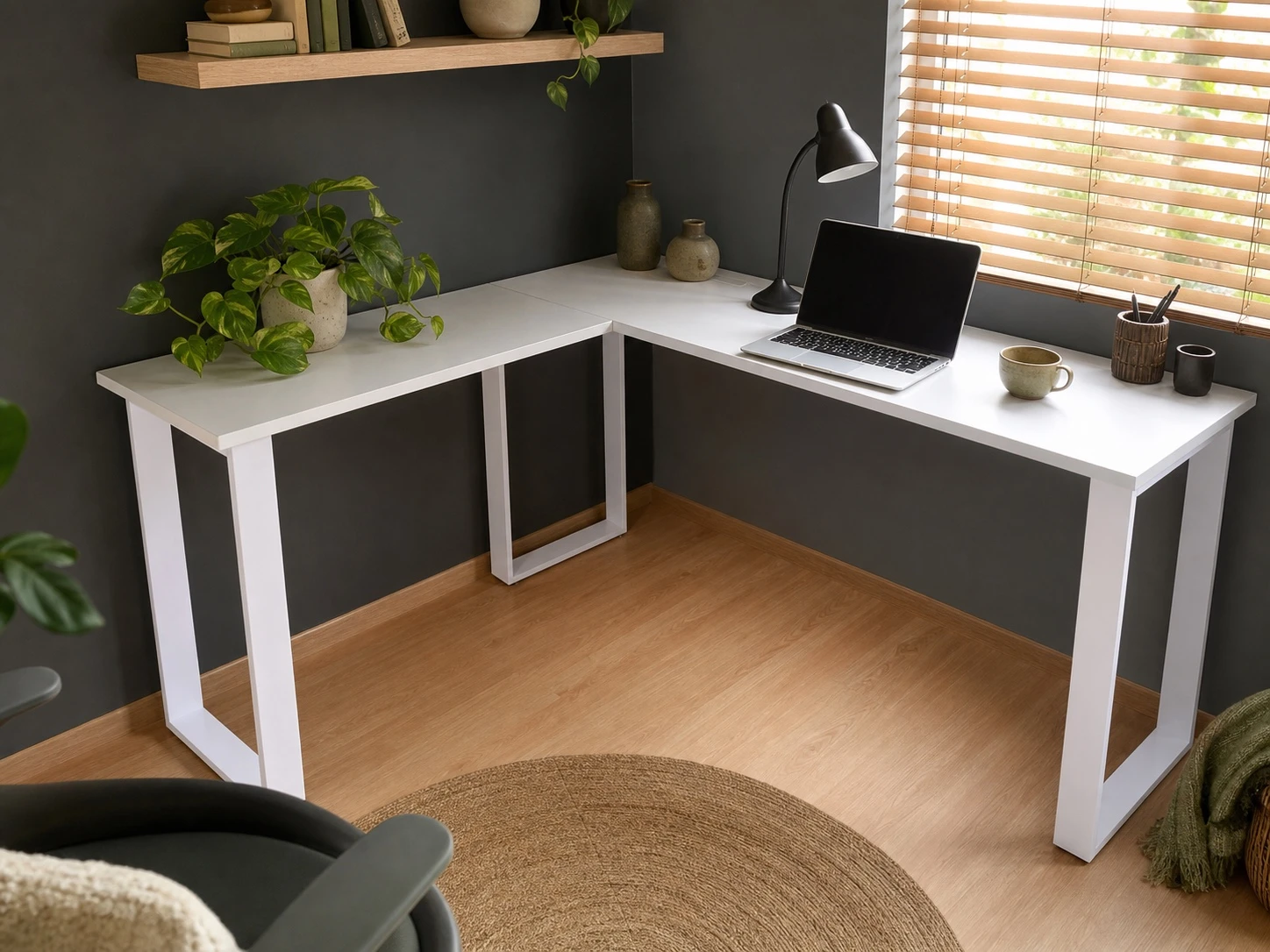 White L-shaped desk with plants, a laptop and warm home-office decor